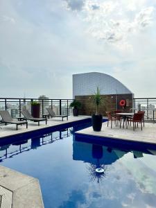 a swimming pool with a table and chairs on a building at Premier Apartment - Hotel Mercure Belém Boulevard in Belém