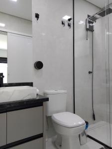 une salle de bain blanche avec toilettes et douche dans l'établissement Nosso Recanto 2 Próximo aos Pontos Turísticos, à Foz do Iguaçu