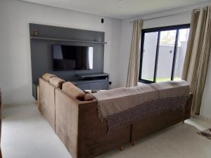 un salon avec un canapé et une télévision dans l'établissement Nosso Recanto 2 Próximo aos Pontos Turísticos, à Foz do Iguaçu