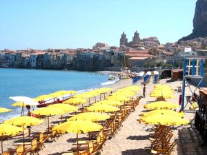 kilka żółtych parasoli na plaży w obiekcie Casa Alba w Cefalù