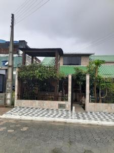 a building with a stone sidewalk in front of it at Kitinete Ubatuba vista mar in São Francisco do Sul