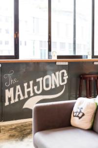 un divano in una stanza con un muro con i malinoidi di The Mahjong a Hong Kong