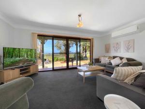 un soggiorno con divano e TV a schermo piatto di Hunter Homestead a Lovedale