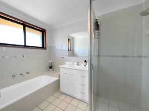 un bagno bianco con vasca e lavandino di Hunter Homestead a Lovedale Altre 8 foto