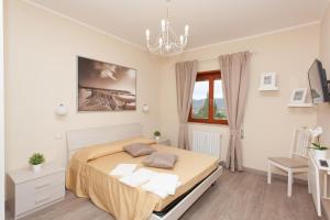 1 dormitorio con cama y lámpara de araña en La Dolce Sosta en Campagnano di Roma