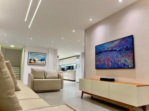 a living room with a couch and a tv on the wall at Residence Dunas Exclusive in Natal