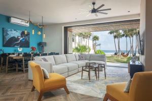 a living room with a white couch and a dining room at Oceanview villa 4BR Concierge Service in Tulum +98 photos