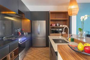 a kitchen with stainless steel appliances and wooden cabinets at Oceanview villa 4BR Concierge Service in Tulum