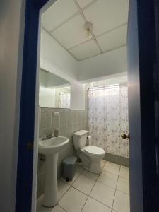a bathroom with a toilet and a sink at Casa Bienestar in Guatemala