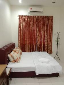 a bedroom with a bed and a window with avertisement at ARUWDA Homestay in Ipoh +10 photos
