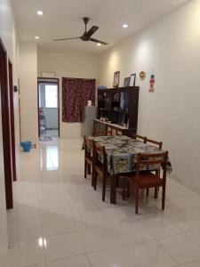 a dining room with a table and chairs and a kitchen at ARUWDA Homestay in Ipoh +10 photos