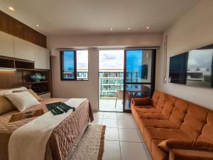 a bedroom with a bed and a couch and windows at MAKIA BEACH EXPERIENCE I Um lar no litoral in Ipojuca