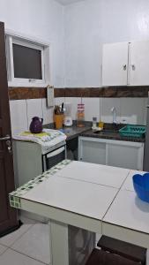 a kitchen with white cabinets and a counter top at Apartamento Morada do Sol in Ilha Comprida