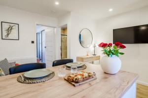 a dining room with a table with a vase of roses at Luxurious One Bedroom Apartment in Perth +19 photos