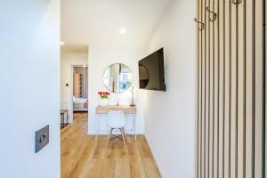 a living room with a table and a mirror at Luxurious One Bedroom Apartment in Perth