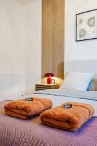 two towels are sitting on top of a bed at Luxurious One Bedroom Apartment in Perth