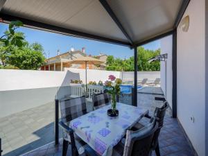 a table with a vase of flowers on a patio at Apartment in Kukci with Heated Pool in Kukci