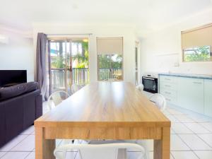 a kitchen and dining room with a wooden table and chairs at Boyne Island Motel and Villas in Boyne Island