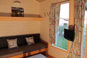 Habitación pequeña con sofá y ventana en Le Hameau des Genets, en Montlaur