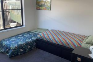 a small bedroom with a bed with a bedskirtspectspectspectspects at 15mins to Mooloolaba Beach opposite Conservation! in Palmview +7 photos
