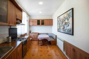 a kitchen with wooden cabinets and a table in it at Modern Condo in the City Center in Yerevan