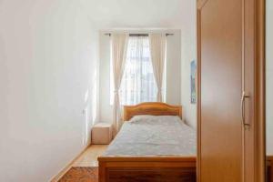 a small bedroom with a bed and a window at Modern Condo in the City Center in Yerevan