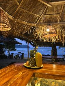 a plate of fruit on a table in a straw hut at The Beach House Bucana Homestay in El Nido