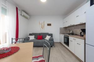 a kitchen and living room with a couch and a table at Apartments by the sea Ribarica, Karlobag - 23603 in Karlobag +13 photos