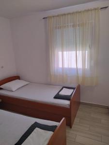a small bedroom with a bed and a window at Apartments by the sea Ribarica, Karlobag - 23603 in Karlobag