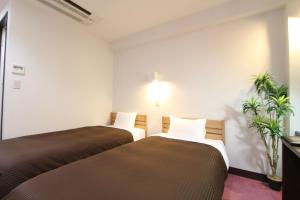 Postel nebo postele na pokoji v ubytování HOTEL LiVEMAX Kitafuchu