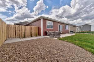 a house with a fence and two chairs in a yard at Highly Accessible, Executive Style, Amazing View! in Rapid City