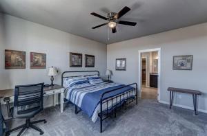 a bedroom with a bed and a desk and a ceiling fan at Highly Accessible, Executive Style, Amazing View! in Rapid City