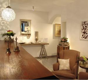 a living room with a table and a chair at Hotel Garni Landhaus Uttum in Greetsiel