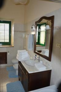 bagno con lavandino, specchio e servizi igienici di Giocasa a Gioiosa Marea