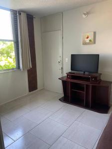 a living room with a flat screen tv on a table at Condomínio Perto da Praia in Cabo Frio