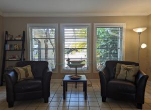 twee stoelen en een tafel in een woonkamer met ramen bij Vacation Home on Coral Sands in Venice