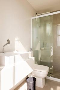 ein Badezimmer mit Toilette und Glasdusche in der Unterkunft Linda e luxuosa cobertura na praia do Forte, Cobertura Sol De Verão in Cabo Frio + 45 Fotos