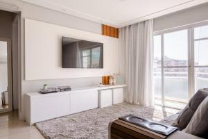 ein Wohnzimmer mit Couch und großem Fenster in der Unterkunft Linda e luxuosa cobertura na praia do Forte, Cobertura Sol De Verão in Cabo Frio