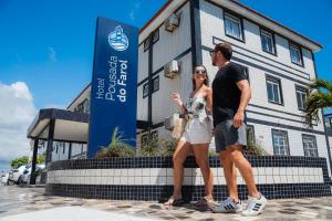 a man and a woman standing in front of a building at Hotel Pousada do Farol in Aracaju