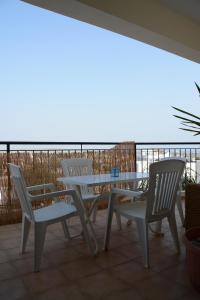 una mesa y sillas en un patio con vistas al océano en Oroklini Hills Apartment, en Oroklini