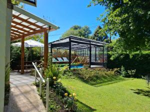 a gazebo with a bench in a garden at Casa Golf in Sierra de los Padres