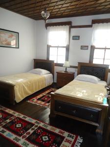 a bedroom with two beds and a rug at Hotel Klea in Berat