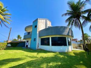 a house with a palm tree in front of it at Casa Alto Padrão de Frente ao Mar in Peruíbe