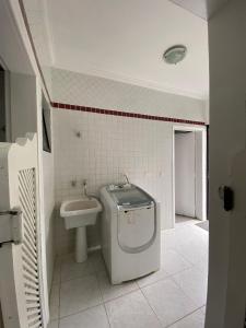 a bathroom with a toilet and a sink at Casa Alto Padrão de Frente ao Mar in Peruíbe