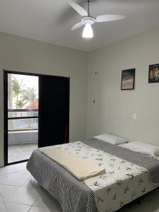 a bedroom with a bed and a ceiling fan at Casa Alto Padrão de Frente ao Mar in Peruíbe +42 photos