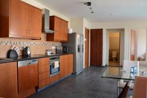 cocina con armarios de madera y nevera de acero inoxidable en Oroklini Hills Apartment, en Oroklini