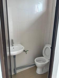 a bathroom with a toilet and a sink at Home2828Stay - ROOMS ONLY in Sibu
