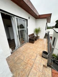 Un patio con un sofá en una casa. en Serendipia, en Maldonado