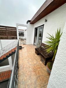 un patio con un banco de madera junto a un edificio en Serendipia, en Maldonado