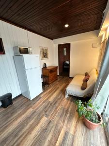 a room with a bed and a refrigerator at Serendipia in Maldonado +2 photos